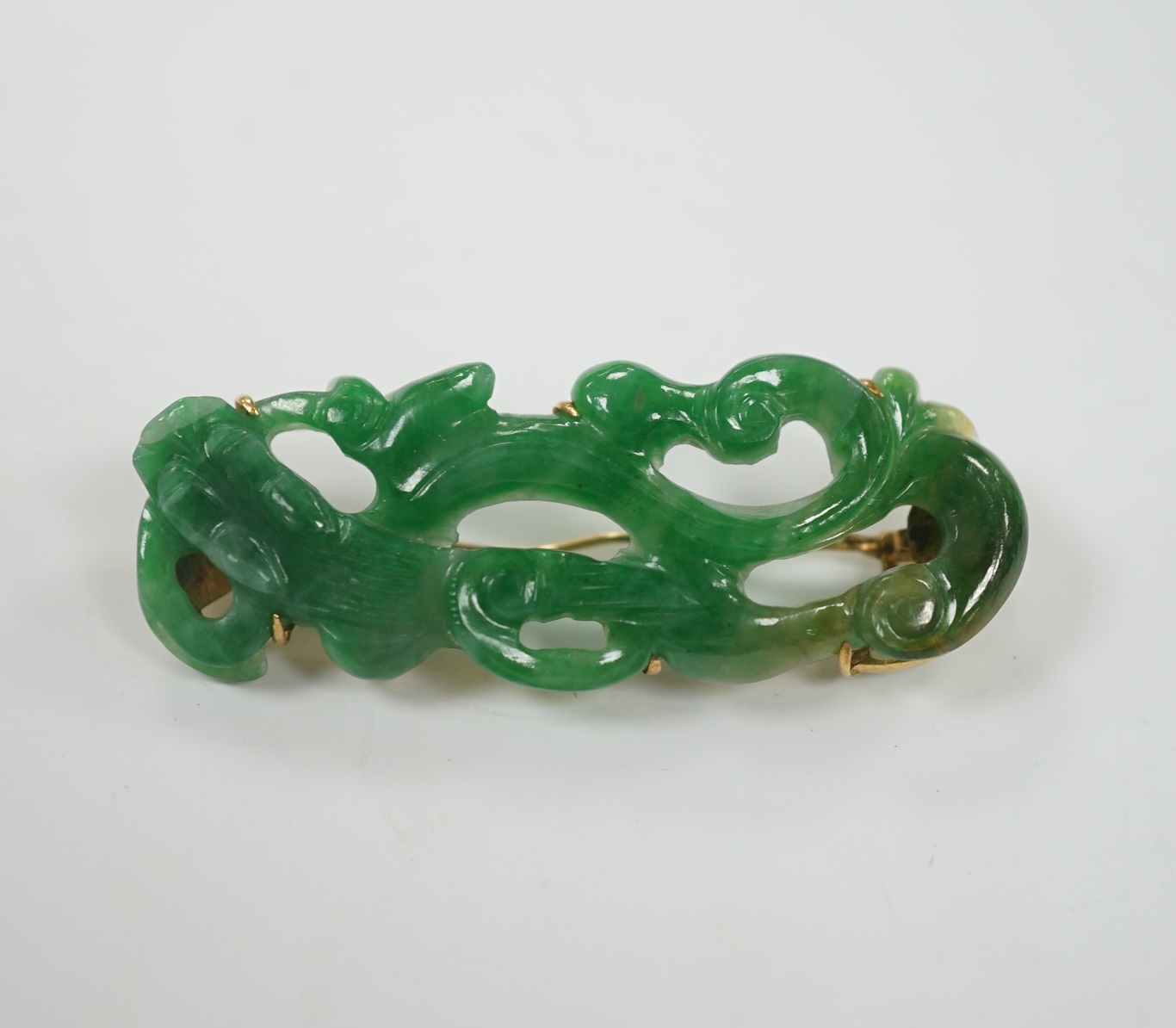 A Chinese 18k mounted carved jade brooch, 50mm, gross weight 9.1 grams.